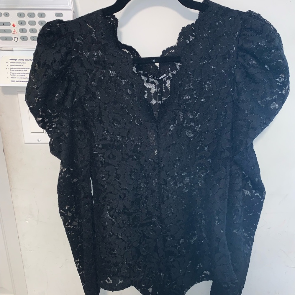 Black bodysuit with puffed shoulders. See through. Snaps closed.
